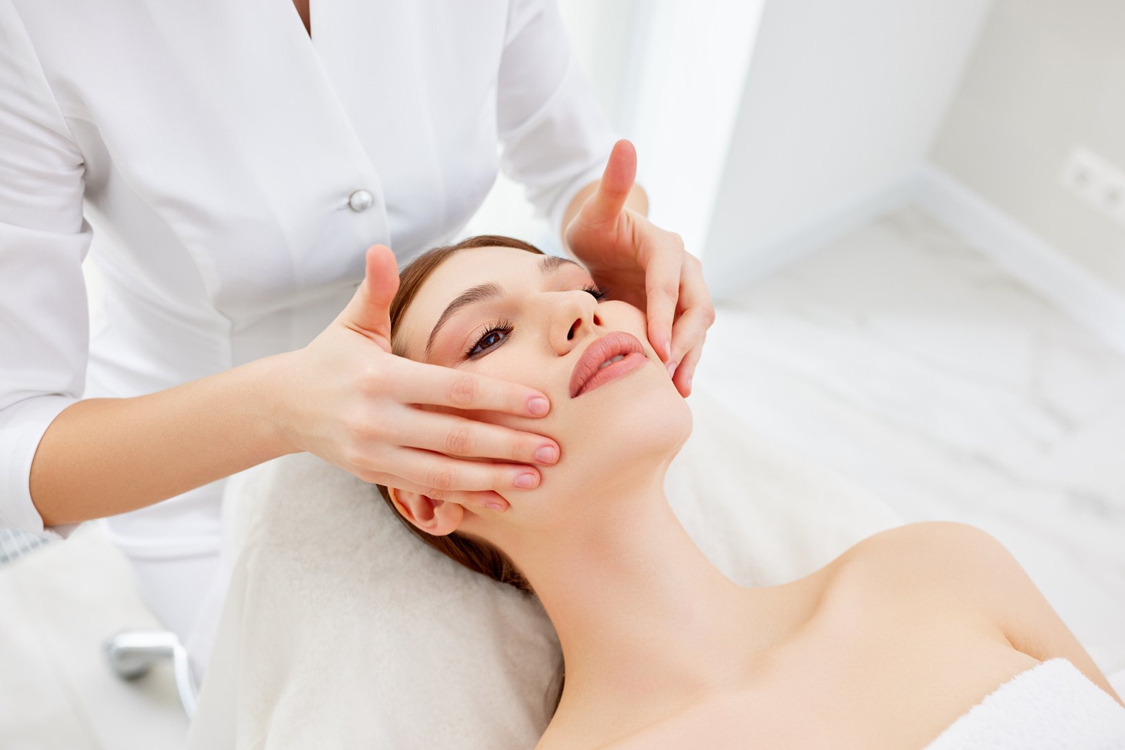 Therapist doing myofascial or buccal massage on face and head fo